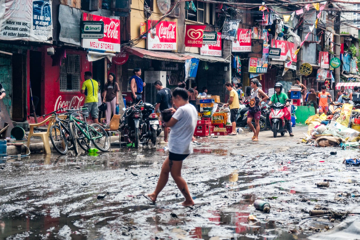 Residents along G. Araneta Avenue, Quezon City are busy cleaning out debris, mud, and wet belongings due to nonstop rains caused by typhoon Carina yesterday. Photo by Yummie Dingding